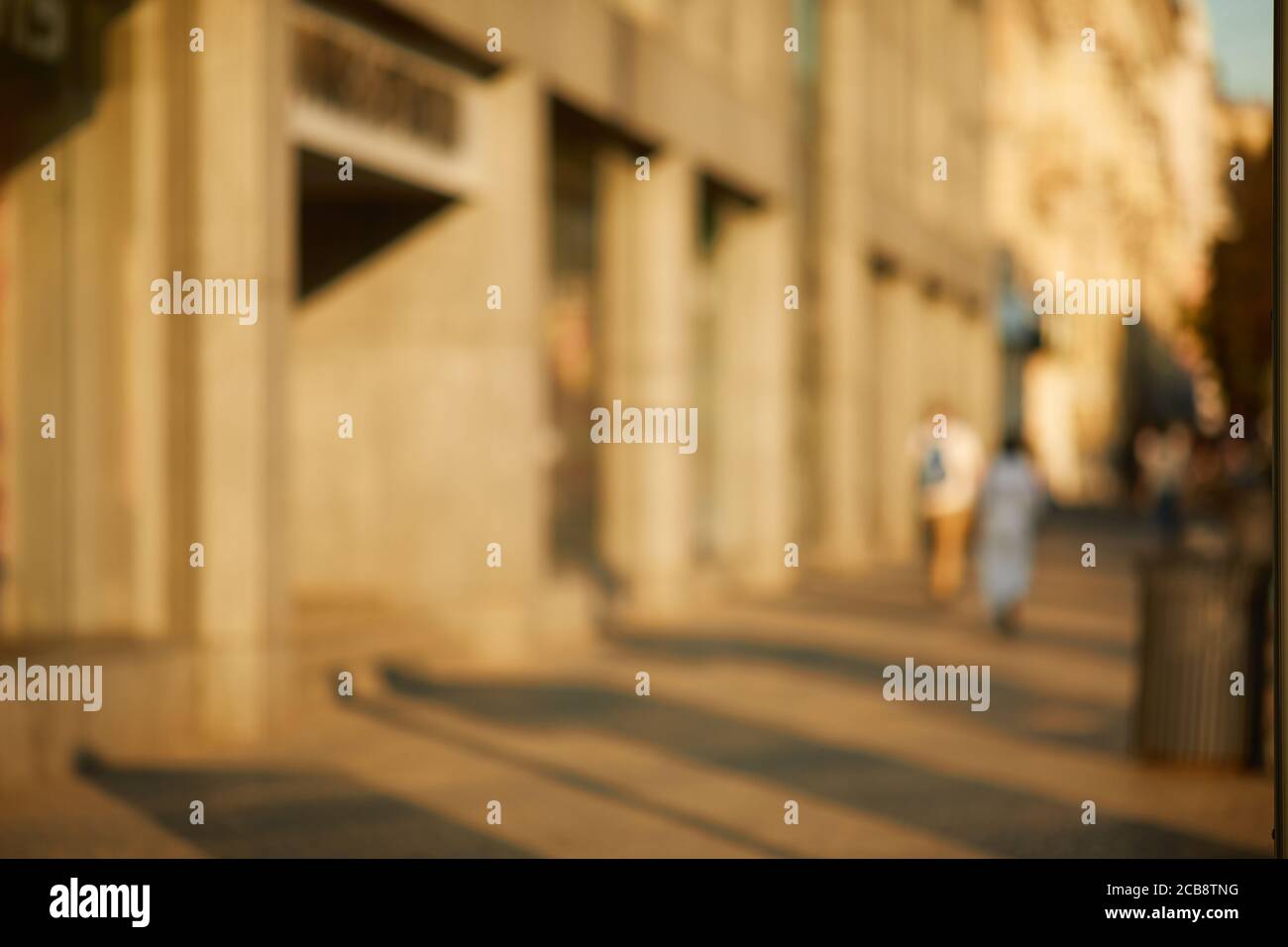 Verwischen Sie die Menschen, die in der sonnigen Straße der Stadt spazieren Stockfoto