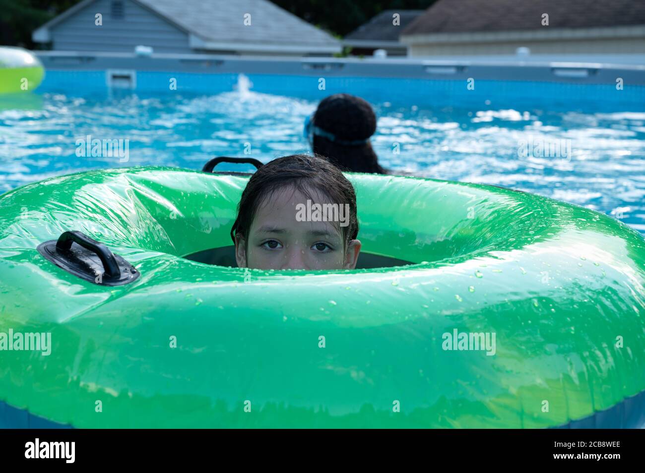 Hübsches Mädchen spielt im Pool während der Sommerzeit. Stockfoto