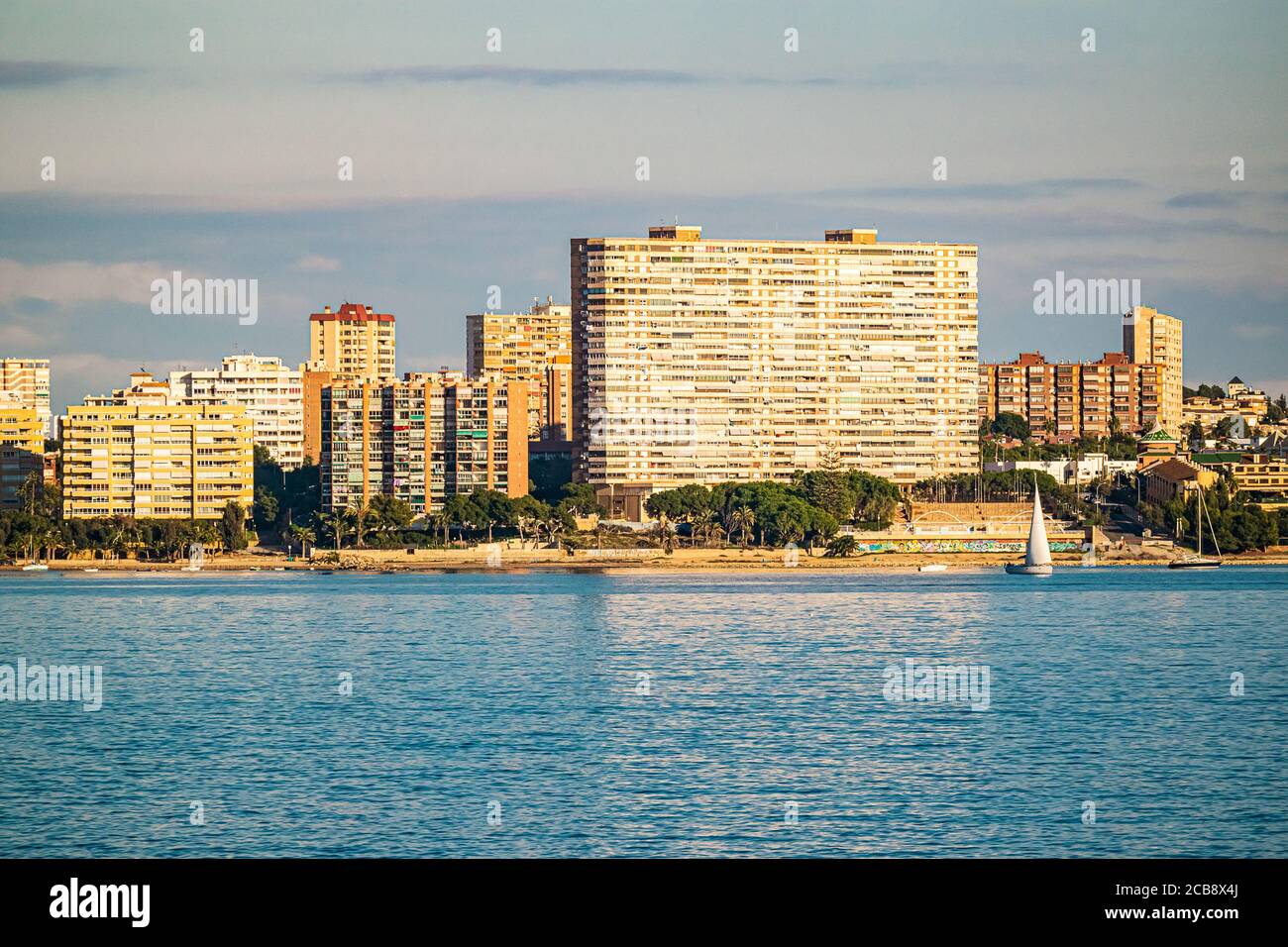 Skyline von San Juan, Alicante, in Spanien, an einem sonnigen Nachmittag mit den 70er Wohnblocks, die sich auf dem Meer spiegeln. Stockfoto