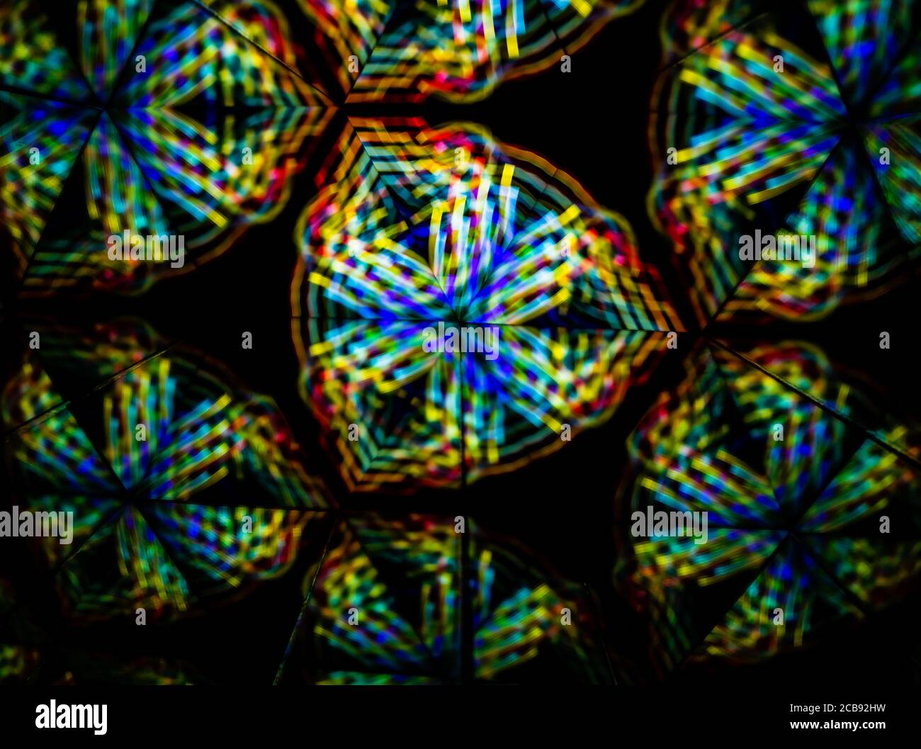 3D-Rendering oder 3D-Rendering. Kaleidoskopisches dreidimensionales Bild. Symmetrie mit farbigen Lichtern auf schwarzem Hintergrund. Stockfoto