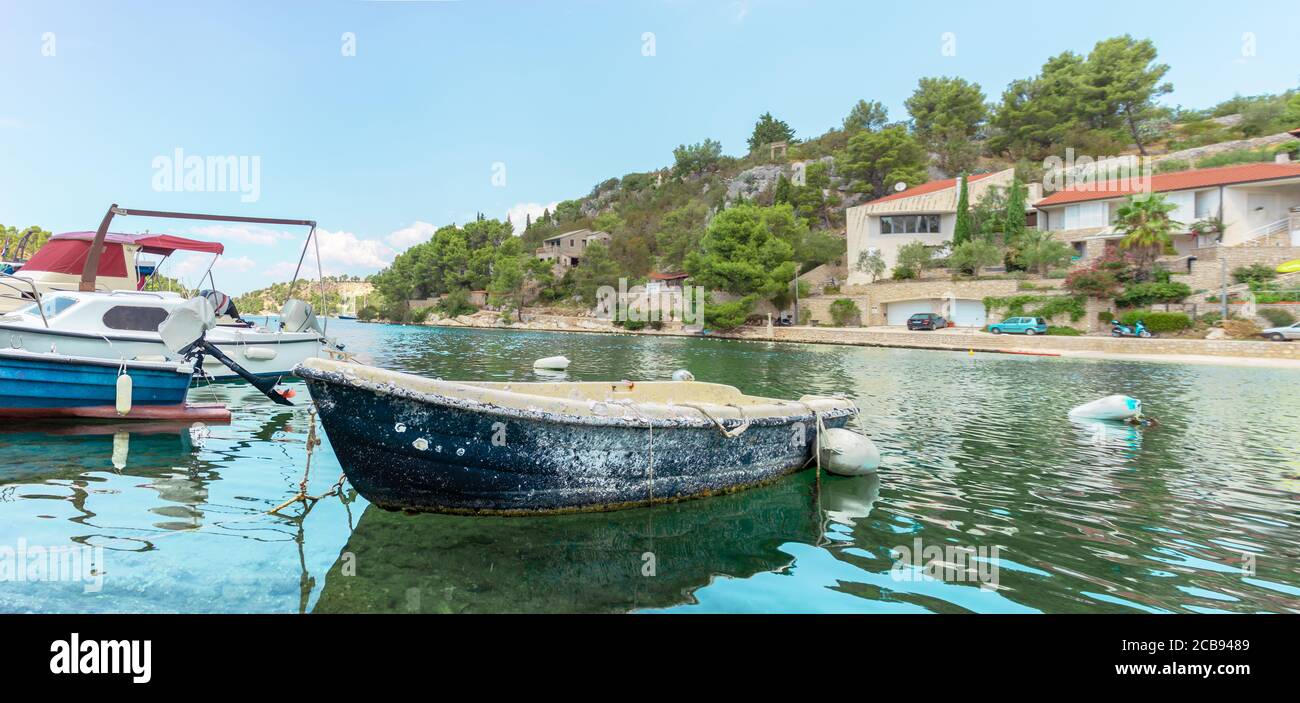 Altes Boot dockte im Hafen von Bobovisca Dorf an. Überwuchert mit Muscheln und Algen als uraltes Relikt der Vergangenheit Stockfoto