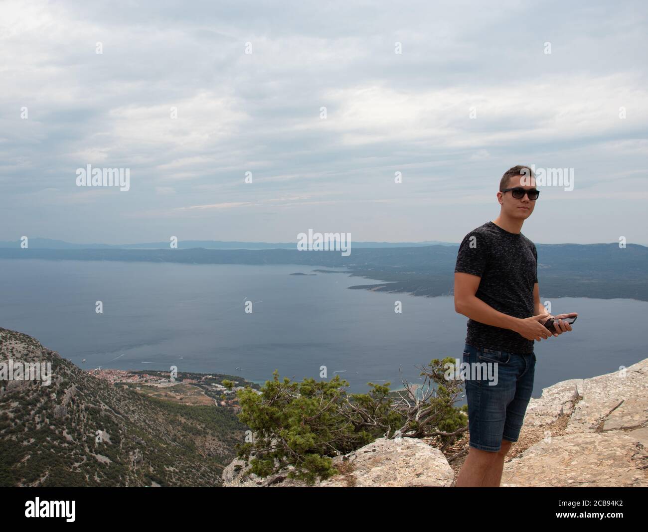 Junger erwachsener Mann, der auf dem Berg Vidova gora, dem höchsten Punkt der Insel Brac, posiert. Beliebter Ort für Touristen zum Fotografieren Stockfoto