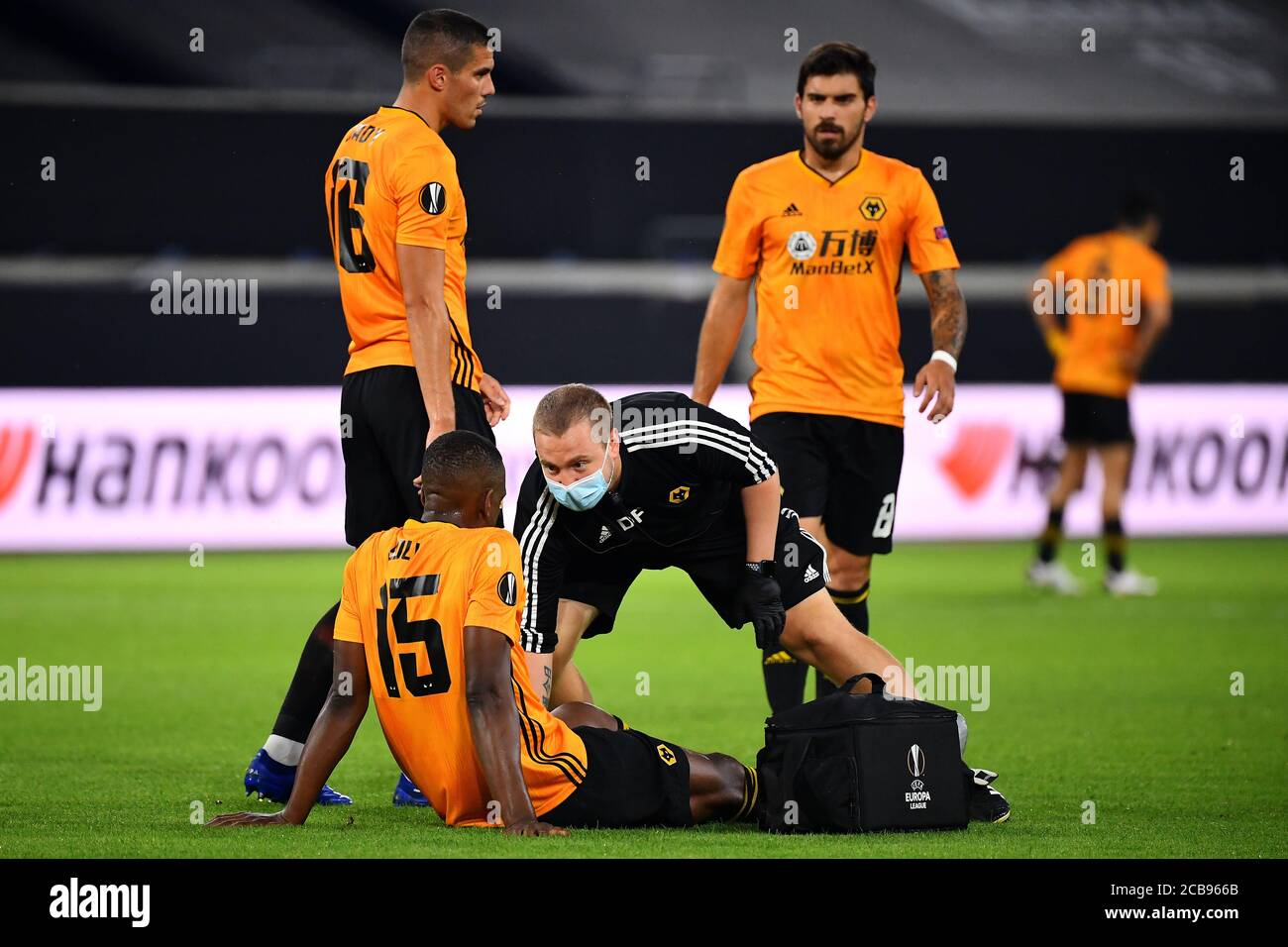 (200812) -- DUISBURG, 12. August 2020 (Xinhua) -- Willy Boly (unten) von Wolverhampton Wanderers wird während des UEFA Europa League Viertelfinales zwischen Wolverhampton Wanderers und dem Sevilla FC in Duisburg, Deutschland, 11. August 2020, medizinisch behandelt. NUR FÜR REDAKTIONELLE ZWECKE. NICHT ZUM VERKAUF FÜR MARKETING- ODER WERBEKAMPAGNEN. (Stuart Franklin/UEFA/Getty/Handout über Xinhua) Stockfoto