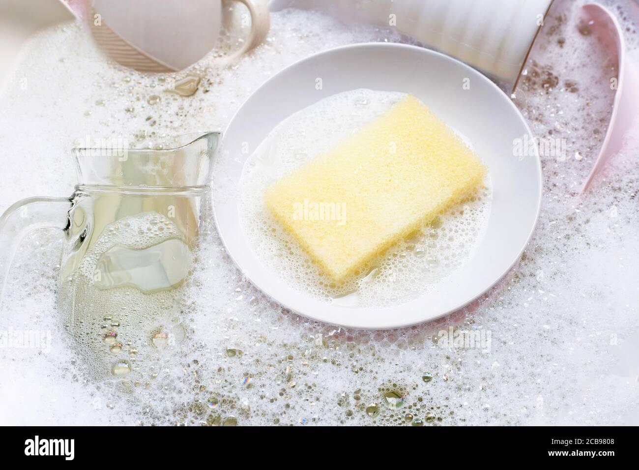 Geschirr waschen, Nahaufnahme der Utensilien, die in der Spüle einweichen. Stockfoto