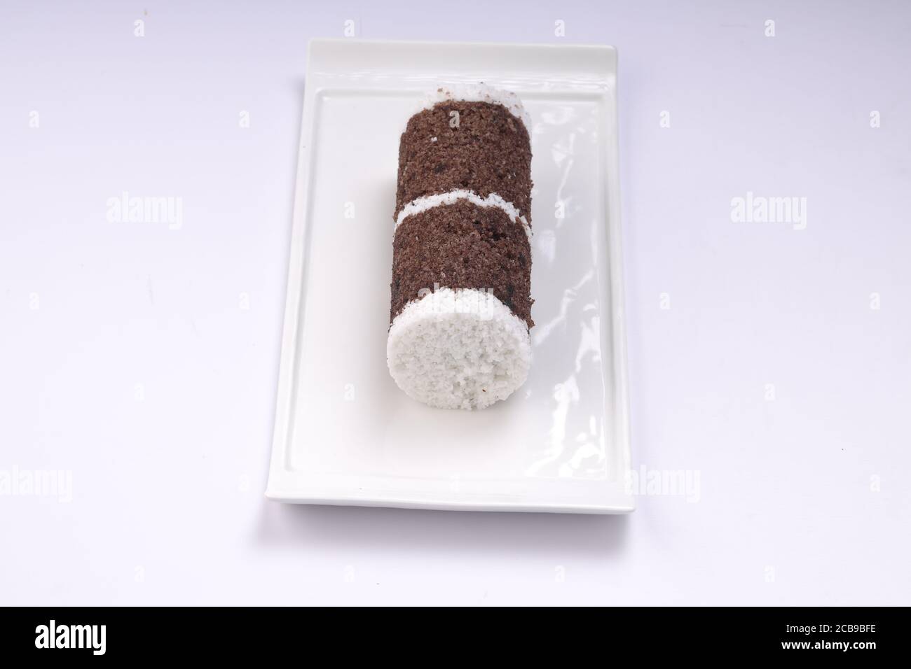 Ragi Puttu oder Millet Puttu, hausgemachtes kerala Frühstück gemacht Mit Fingerhirse und Kokosnüsse, gesunde indische Lebensmittel auf gelegt Ein weißes Geschirr Stockfoto