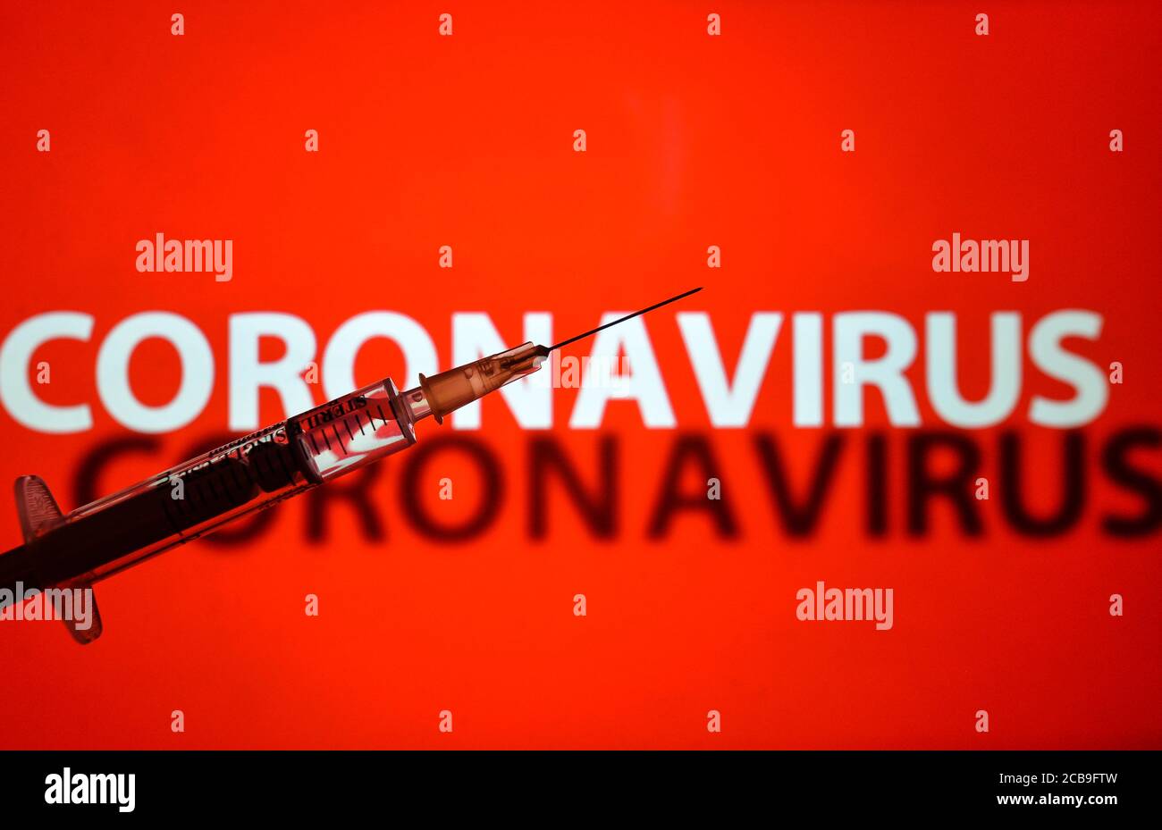 In dieser Fototafel eine medizinische Spritze und 'Coronavirus' Inschrift im Hintergrund. Stockfoto