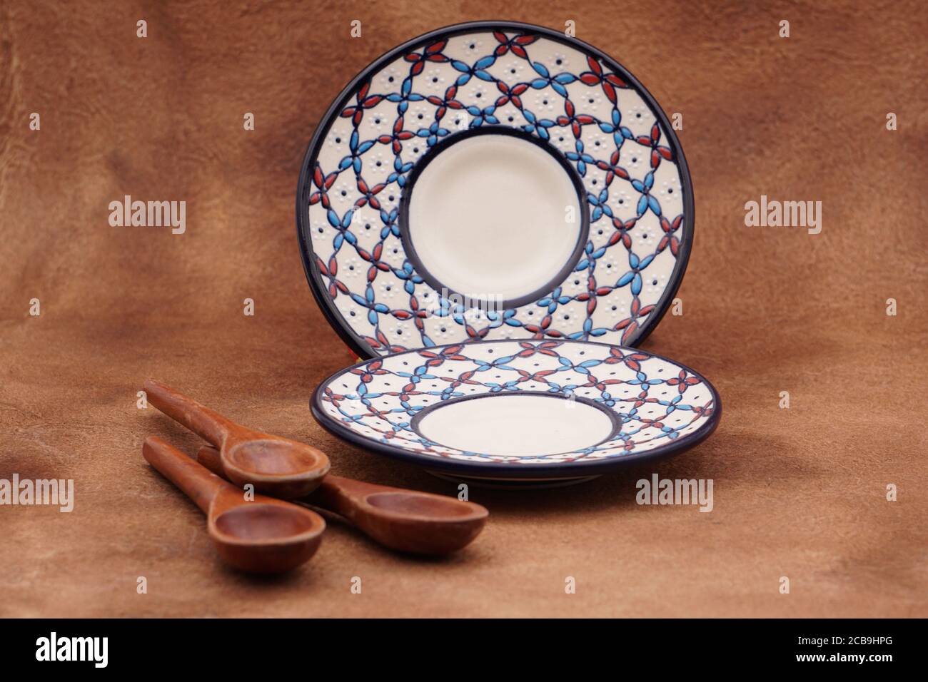 Kaffeeteller mit traditionellem Design und Holzlöffeln Mit braunem Hintergrund Stockfoto