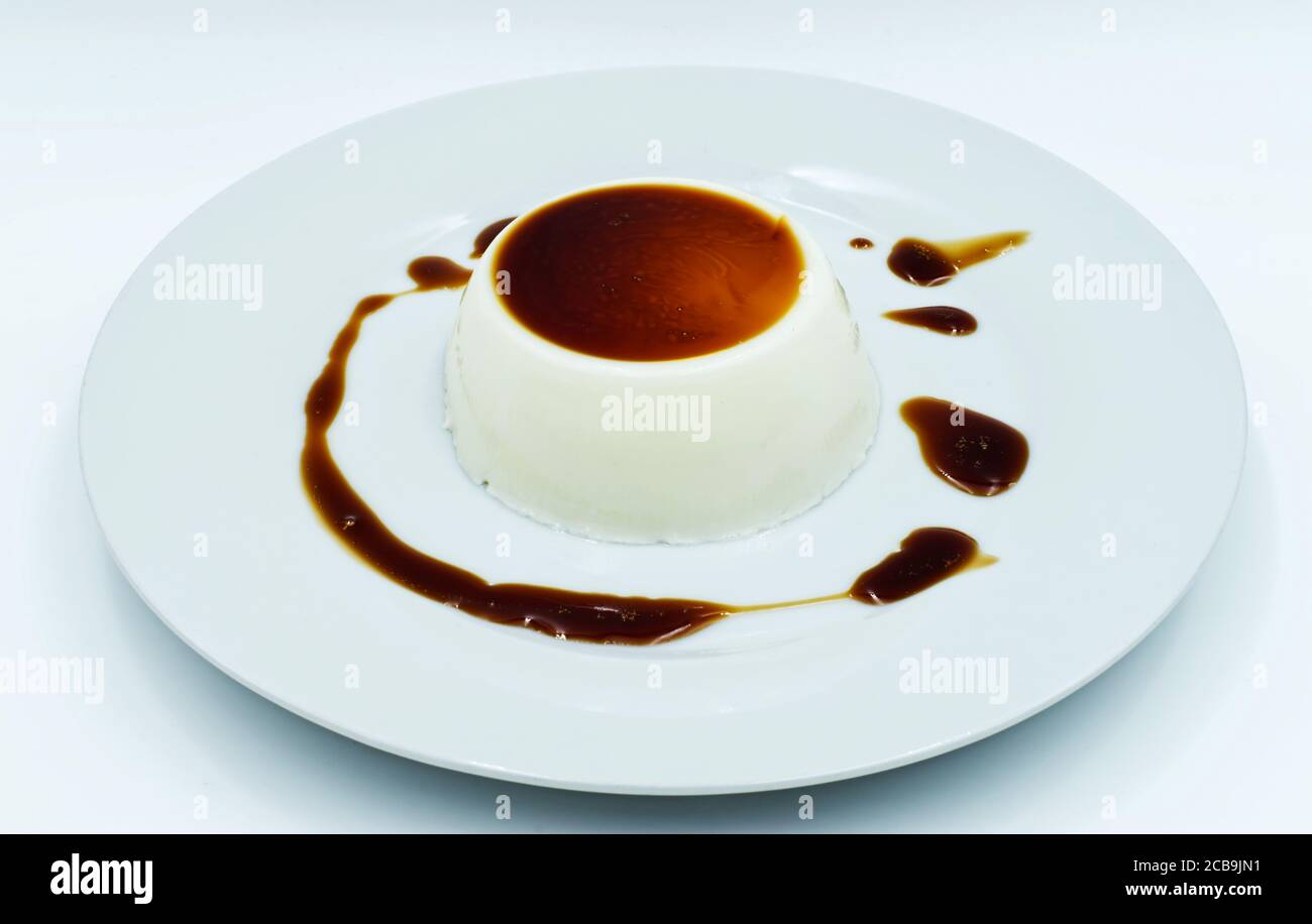 Panna Cotta mit Karamellsauce auf einem weißen Teller. Köstliches italienisches Dessert Stockfoto