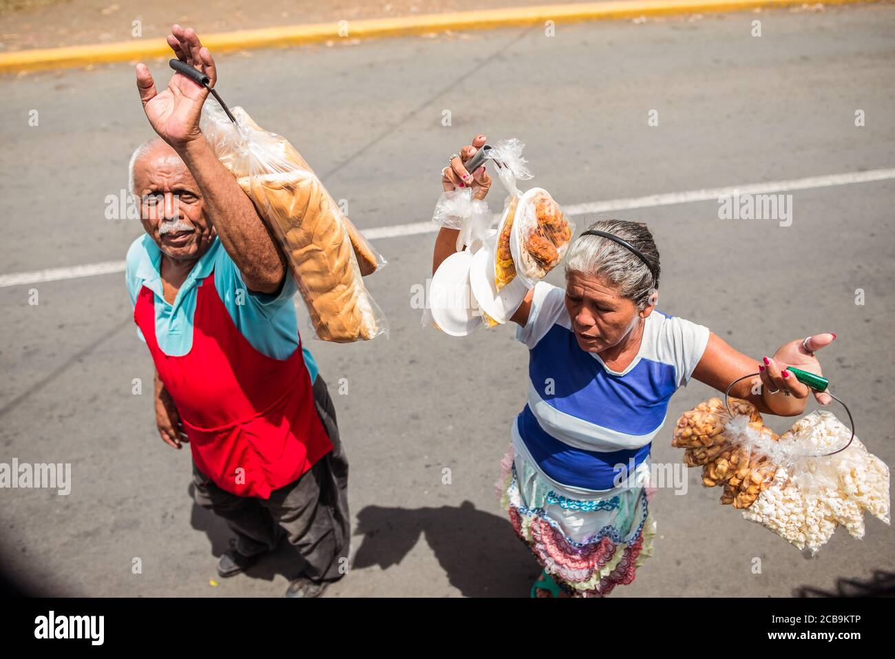 Jinotega / Nicaragua - 28. Juli 2019: Mann und Frau verkaufen lokale Lebensmittel an Busfahrgäste Stockfoto