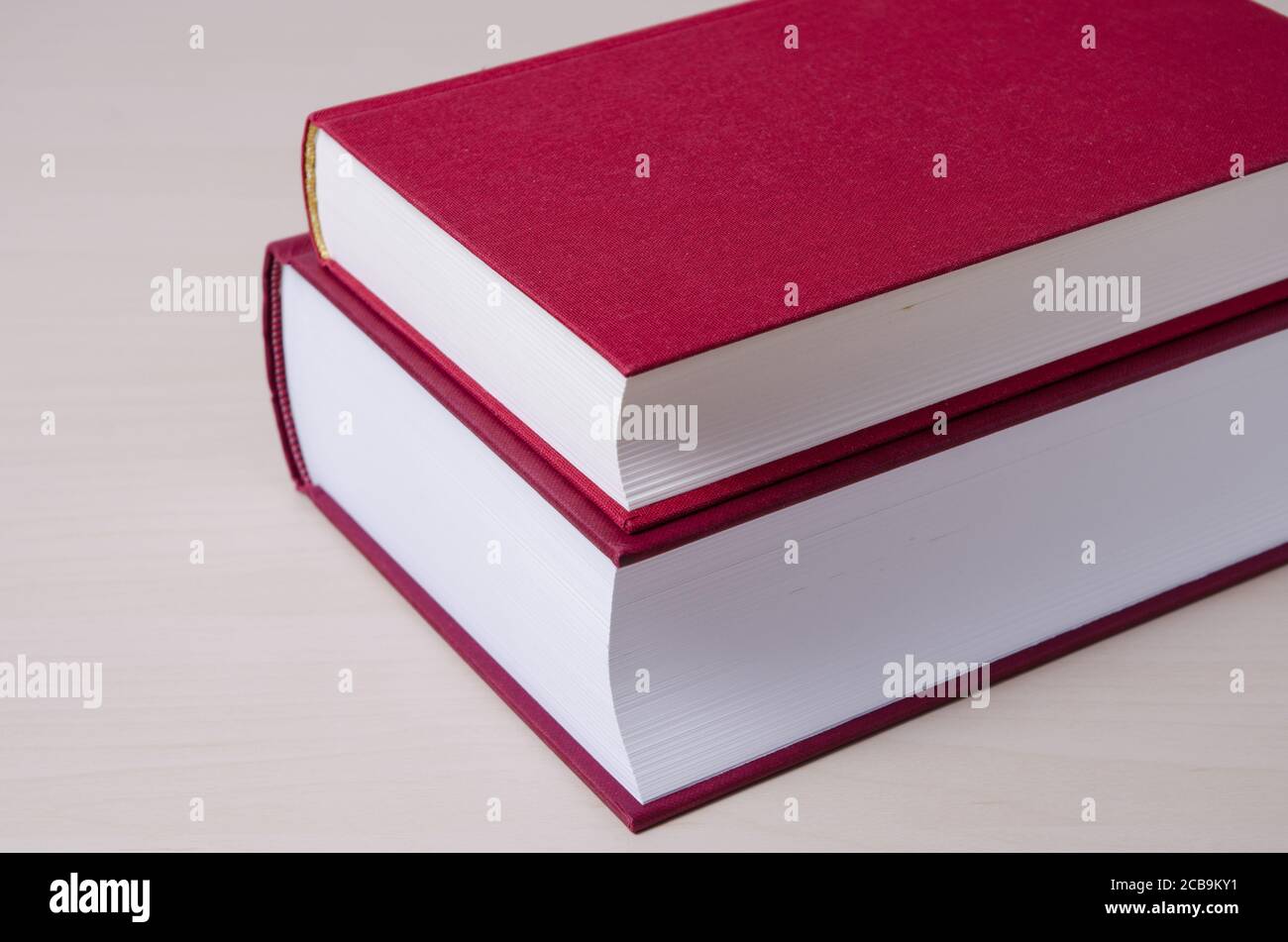 Zwei rote Hardcover-Bücher auf Holztisch oder Schreibtisch, innen, Literatur, Bibliothek Bildung Lesekonzept Stockfoto