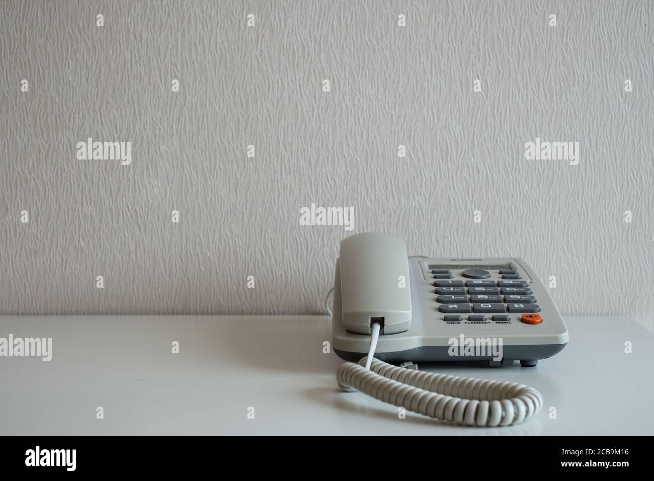 Telefon auf dem Schreibtisch mit grauem Wandhintergrund Stockfoto