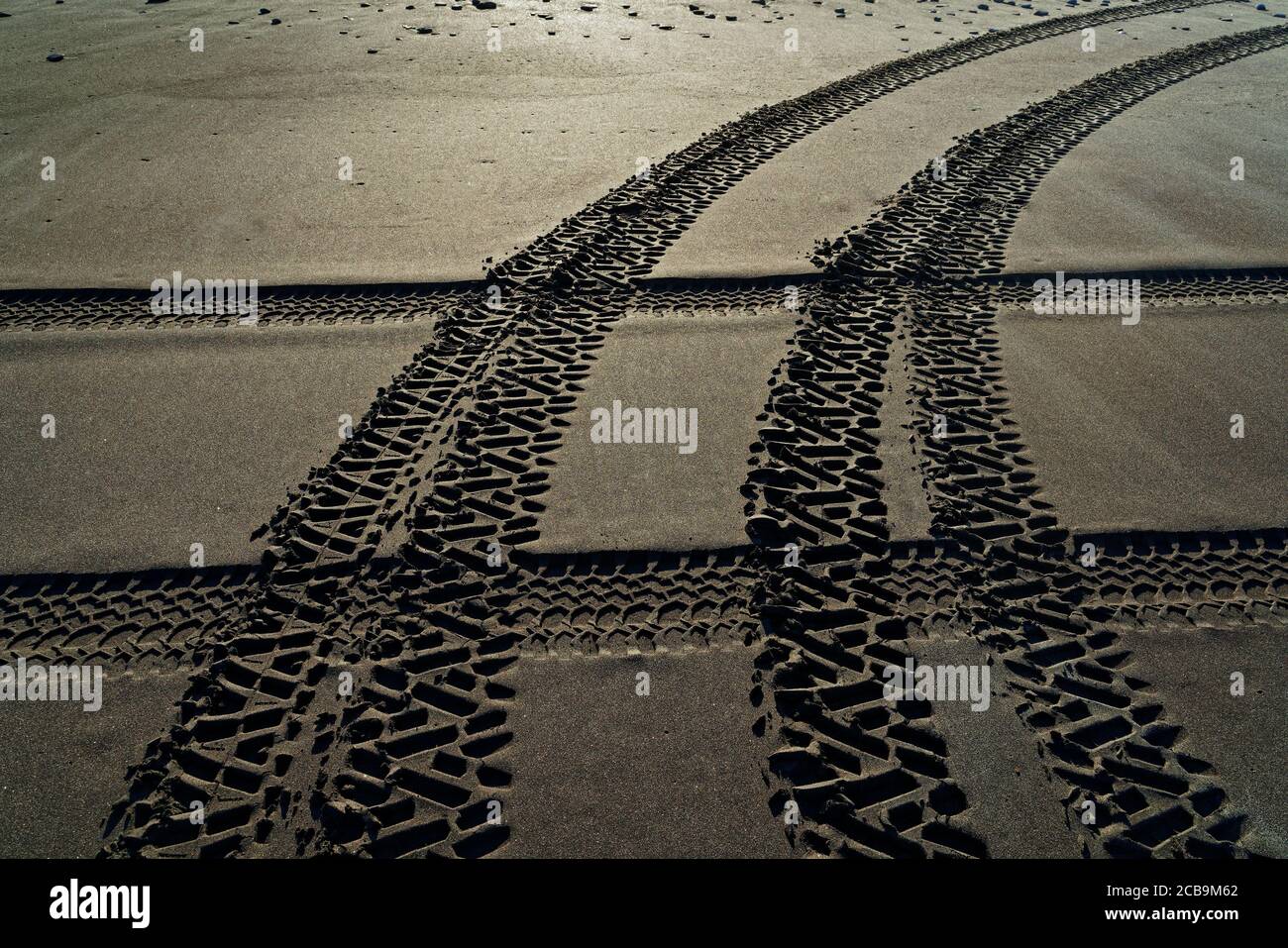 Criss Cross Allradantrieb Fahrzeug Reifenspuren an einem Strand, Neuseeland. Stockfoto