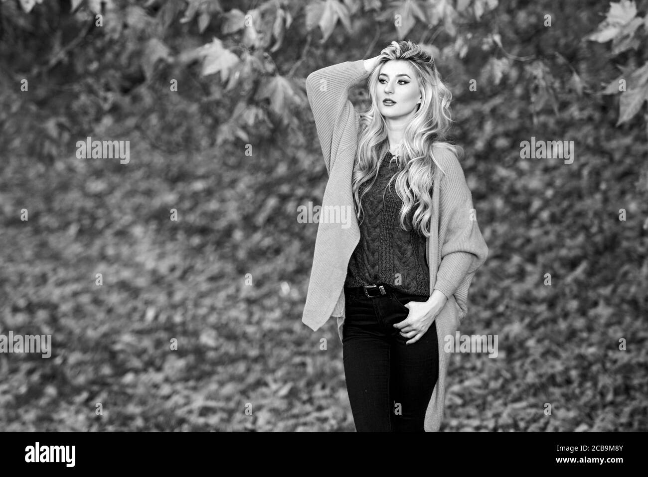 Gemütliche zwanglose Outfits für den Herbst. Mädchen niedliche Blondine posiert in warmen und gemütlichen Outfit Herbst Natur Hintergrund Defokussierten. Gemütliche outfit Ideen für das Wochenende. Frau Spaziergang bei Sonnenuntergang. Komfortable Ausstattung. Stockfoto
