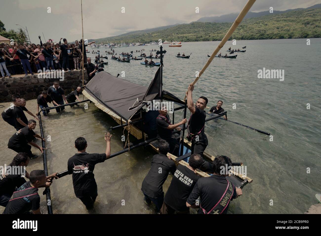 Larantuka, Indonesien. April 2015. Mitglieder des Kirchenkomitees setzen das Boot mit einer Holzkiste mit der Statue des Jesuskindes traditionell als Tuan Meninu bekannt, vor Karfreitag Meer Prozession am Strand der Tuan Meninu Kapelle in Larantuka, Flores Insel, Indonesien. Stockfoto