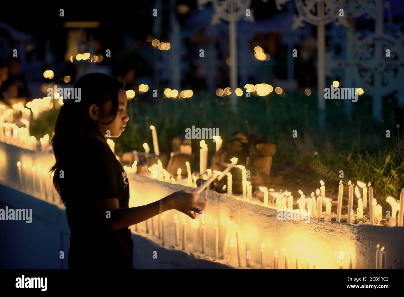 Larantuka, Indonesien. April 2015. Ein Kind zündet Kerzen auf dem Friedhof der Larantuka Kathedrale während des Karfreitagsgedenkens in Larantuka, Insel Flores, Indonesien. Stockfoto