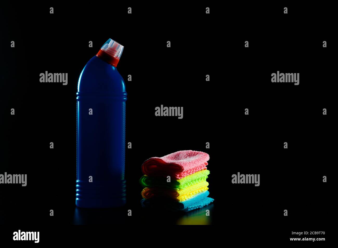 Blauer Toilettenreiniger mit Lumpen auf schwarzem Hintergrund. Stockfoto
