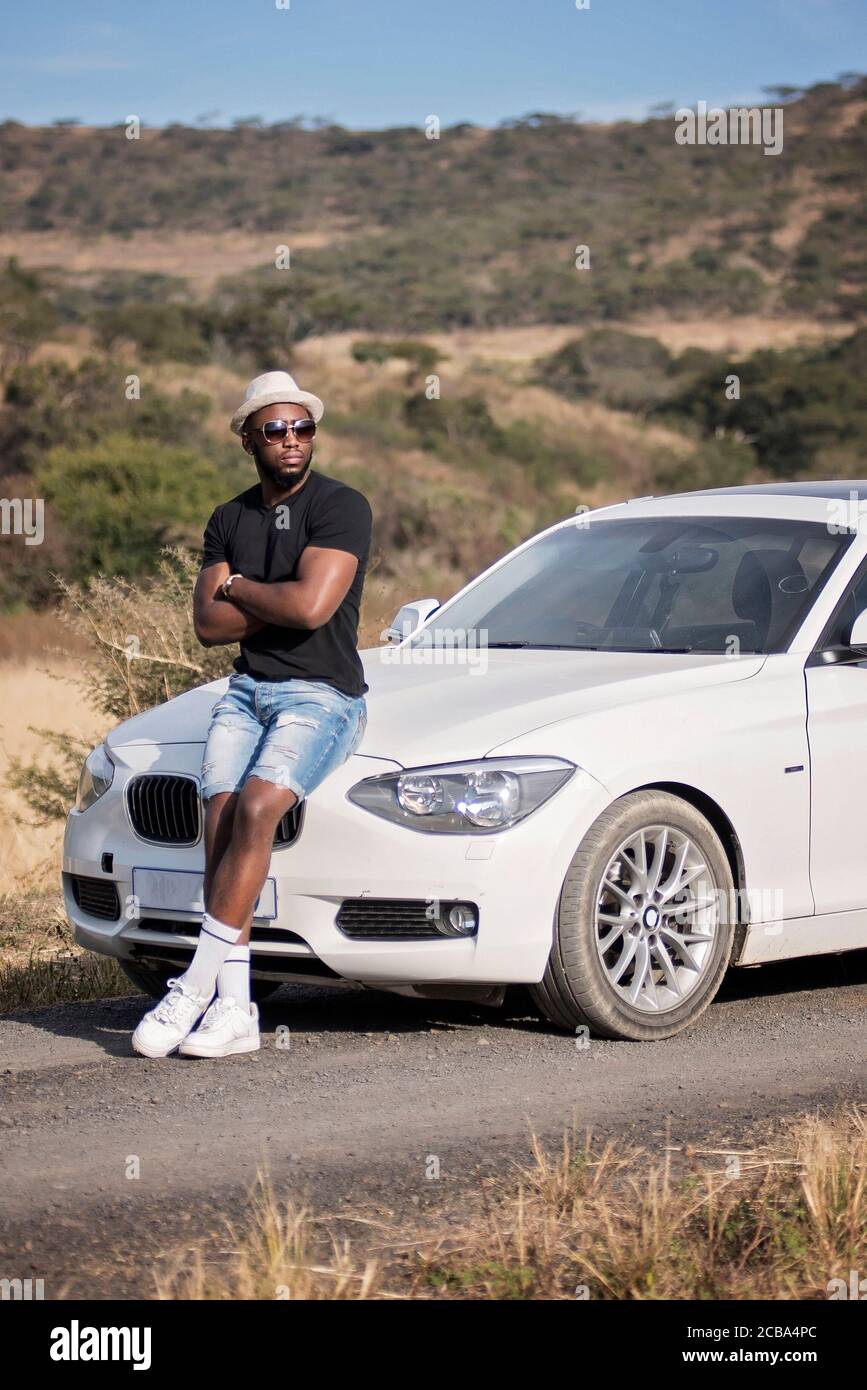 Erfolgreicher afrikanischer oder afroamerikanischer Schwarzmann auf Safari mit Luxuswagen Stockfoto