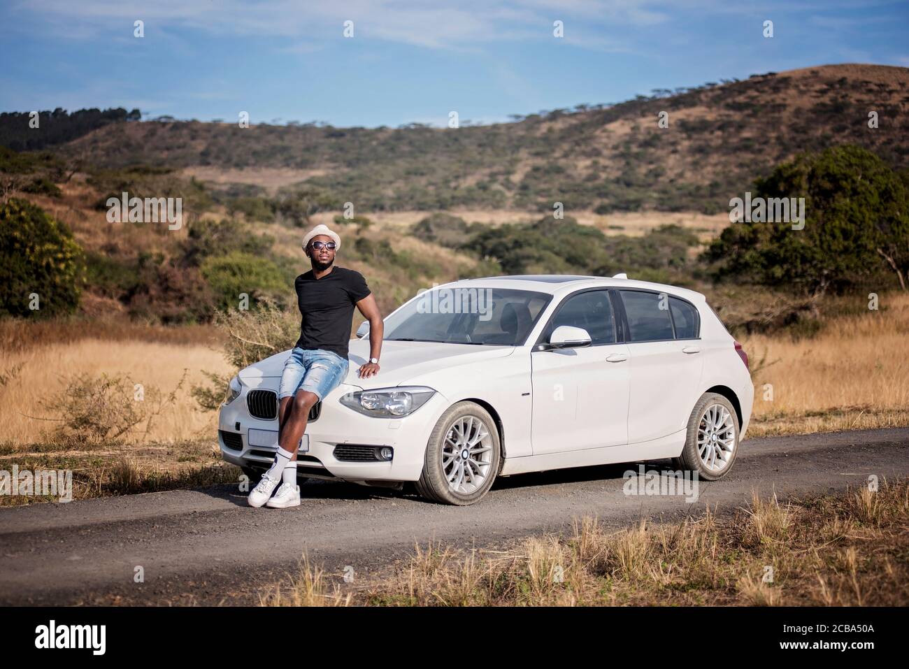 Erfolgreicher afrikanischer oder afroamerikanischer Schwarzmann auf Safari mit Luxuswagen Stockfoto