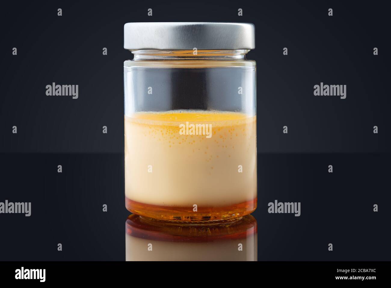 Creme Karamell in einem Glas isoliert auf schwarzem Hintergrund Stockfoto
