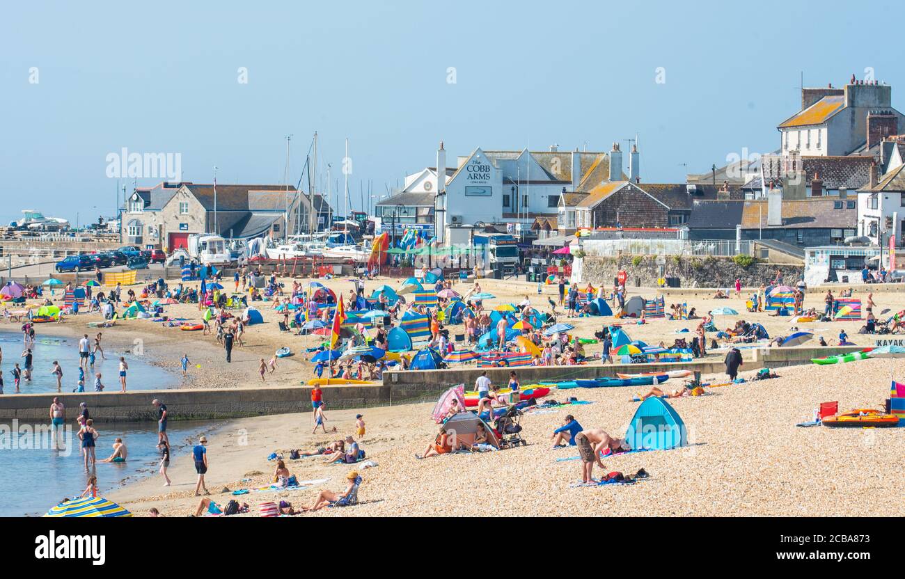 Lyme Regis, Dorset, Großbritannien. August 2020. UK Wetter: Urlauber, Familien und Sonnenanbeter schweben im Seebad Lyme Regis in glühender heißer Sonne, da die rekordbrechenden Temperaturen wieder steigen. Die Hitze am Strand war schon um 10.30 Uhr intensiv. Kredit: Celia McMahon/Alamy Live Nachrichten Stockfoto