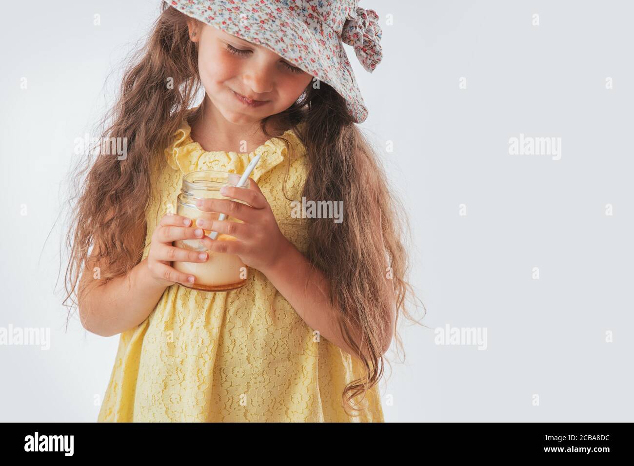 Schöne kleine Mädchen mit Löffel im Mund essen leckere Sahne. Lecker Eis zu essen macht Spaß Stockfoto