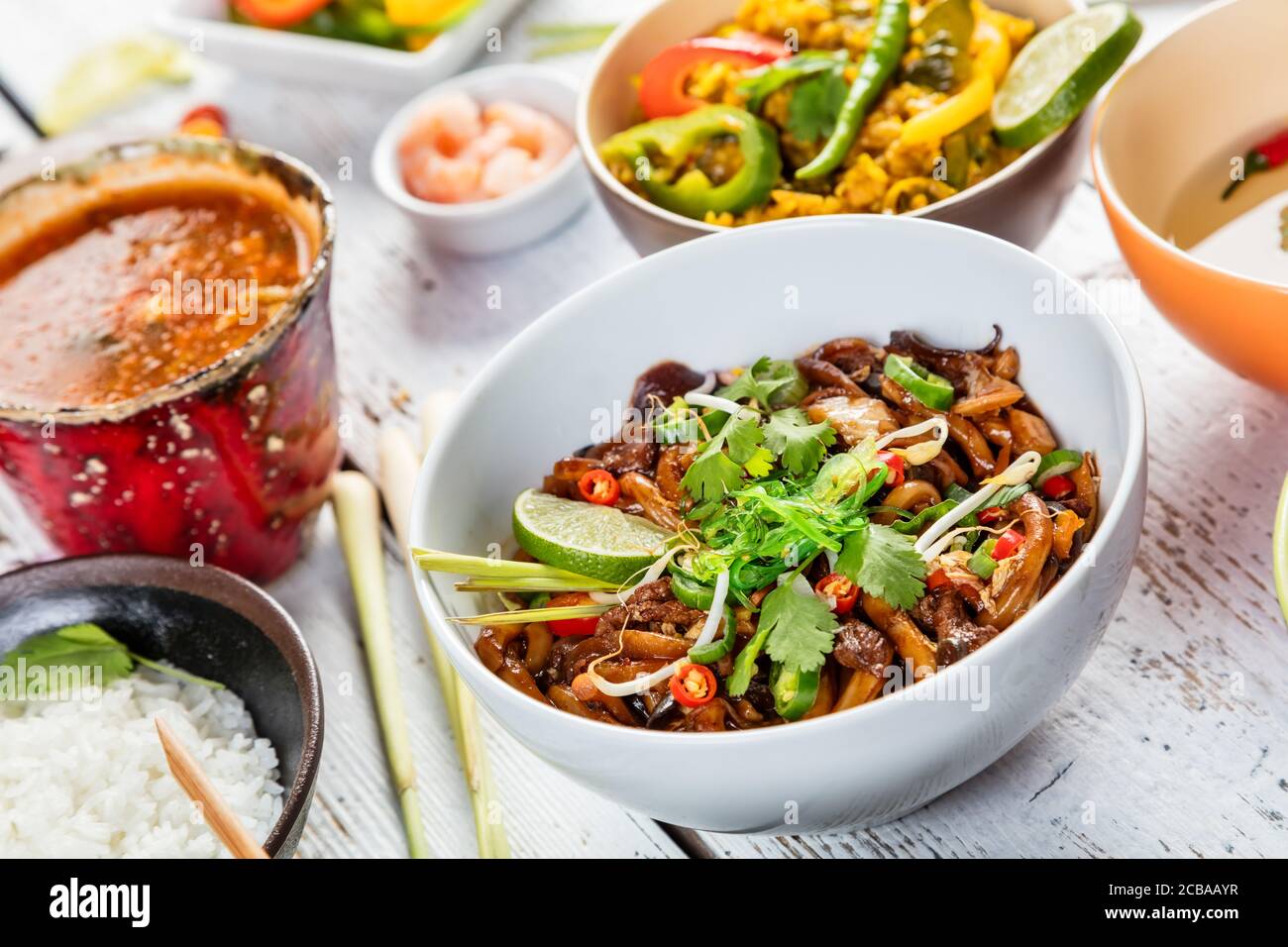 Asiatische Huhn und Garnelen Curry mit Reis und Frühlingsrollen Stücke, auf alten Holzbrettern serviert. Stockfoto