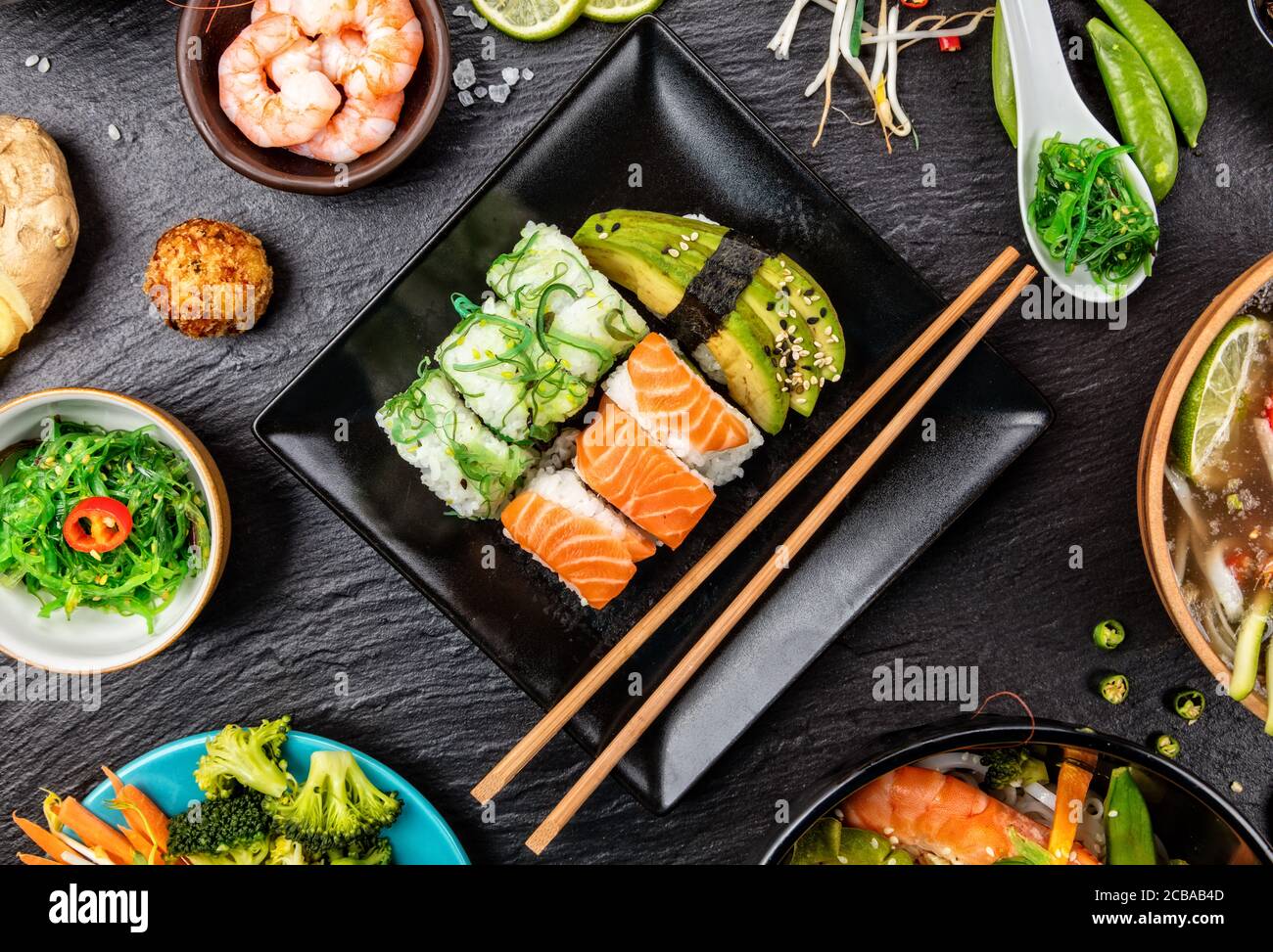Asiatische Sushi Variation mit vielen Arten von Mahlzeiten. Kari, Suppe, Reis und Gemüse. Ansicht von oben, auf schwarzen Stein serviert. Stockfoto