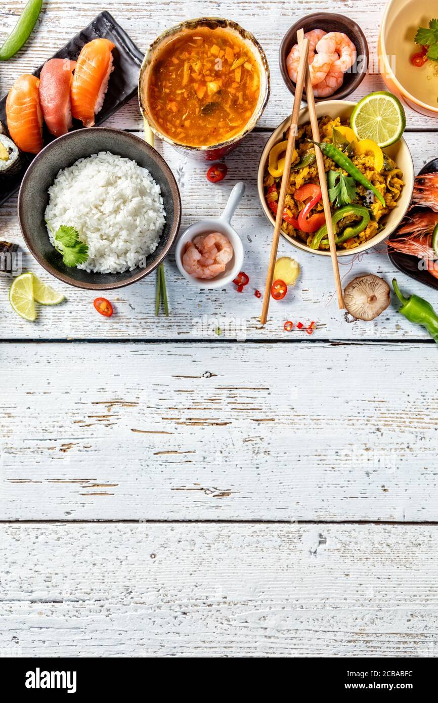 Asiatische Lebensmittel Variation mit vielen Arten von Mahlzeiten. Kari Reis, Nudeln und Gemüse. Ansicht von oben, auf alten Holzbrettern serviert. Stockfoto