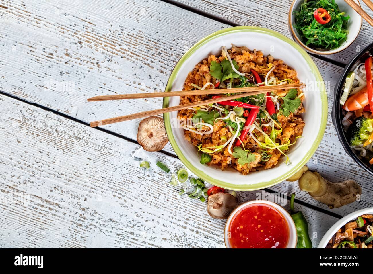 Asiatische Huhn und Garnelen Curry mit Reis und frisches Gemüse, Ansicht von oben, auf alten Holzbrettern serviert. Stockfoto