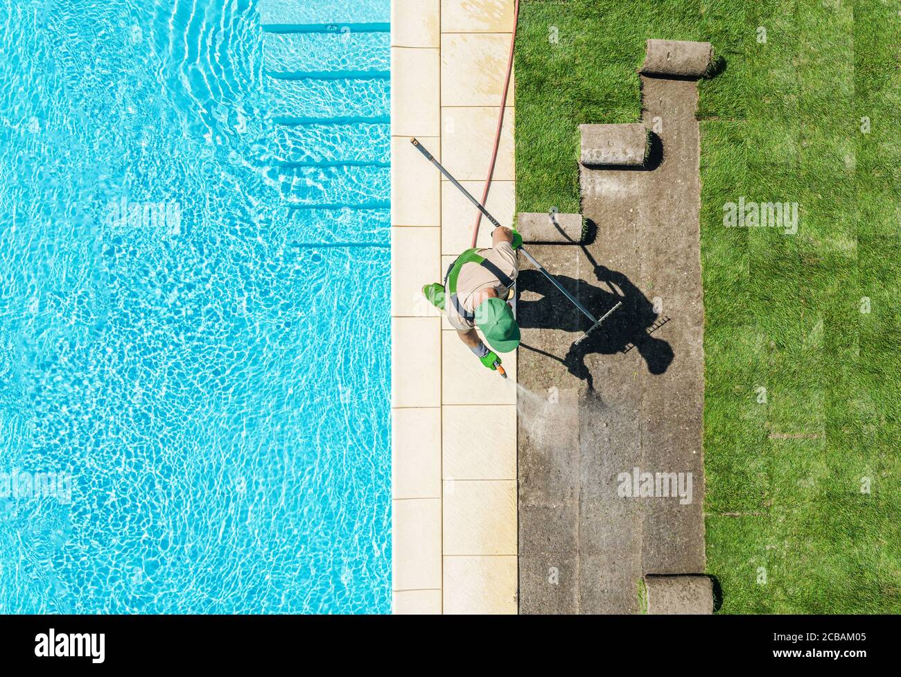 Professionelle kaukasischen Gärtner in seinen 40er Jahren Finishing Rasen um Schwimmbad Installation von neuen Grass Rasen. Landschaftsbau Thema. Stockfoto