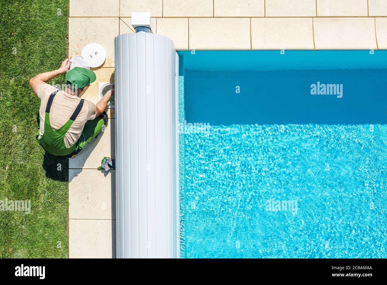 Thema Der Freizeitbranche. Private Outdoor-Pool Skimmer Filter Reinigung von professionellen kaukasischen Pool Technician. Luftaufnahme. Stockfoto