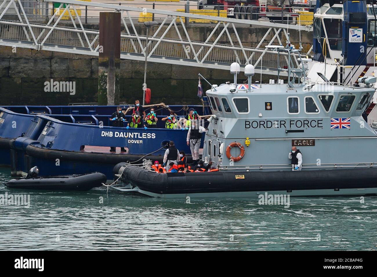 Eine Gruppe von Menschen, die als Migranten gedacht werden, werden von Grenzschutzbeamten nach Dover, Kent, gebracht, nachdem einige kleine Bootsvorfälle im Kanal heute vorgekommen waren. Stockfoto