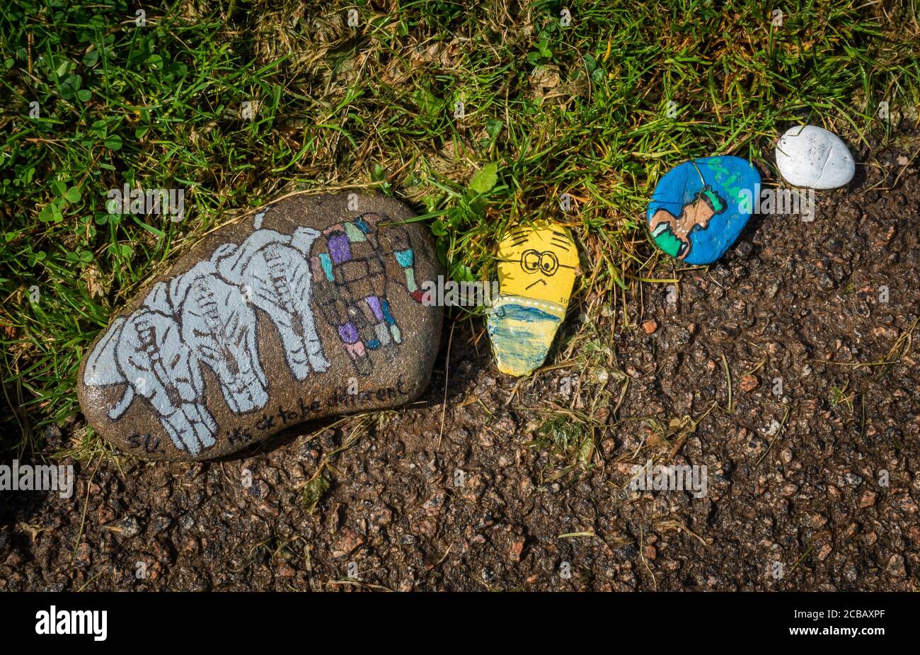 Steine, die von Kindern während der Covid19-Sperre in Großbritannien gemalt wurden, einschließlich eines mit der Aufschrift „Es ist in Ordnung, anders zu sein“ Stockfoto