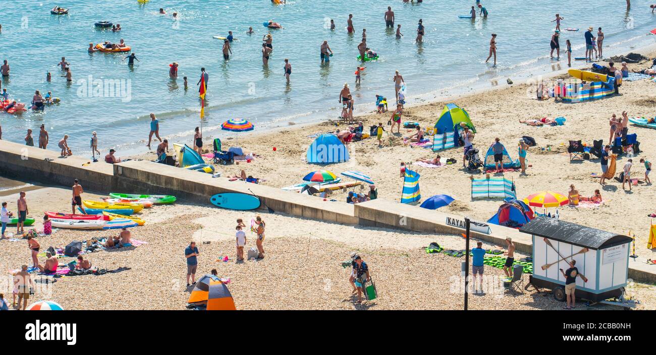 Lyme Regis, Dorset, Großbritannien. August 2020. UK Wetter: Massen von Urlaubern, Strandgänger, und Sonnenanbeter strömen an diesem Nachmittag zum Strand am Badeort Lyme Regis, um sich in der heißen Sonne zu sonnen, während die Hitzewelle anhält. Die Menschen tauchen im Meer ein, während die sengende Hitze und sengende Sonne wieder Höhen von über 30 Grad celsius erreicht. Kredit: Celia McMahon/Alamy Live Nachrichten Stockfoto