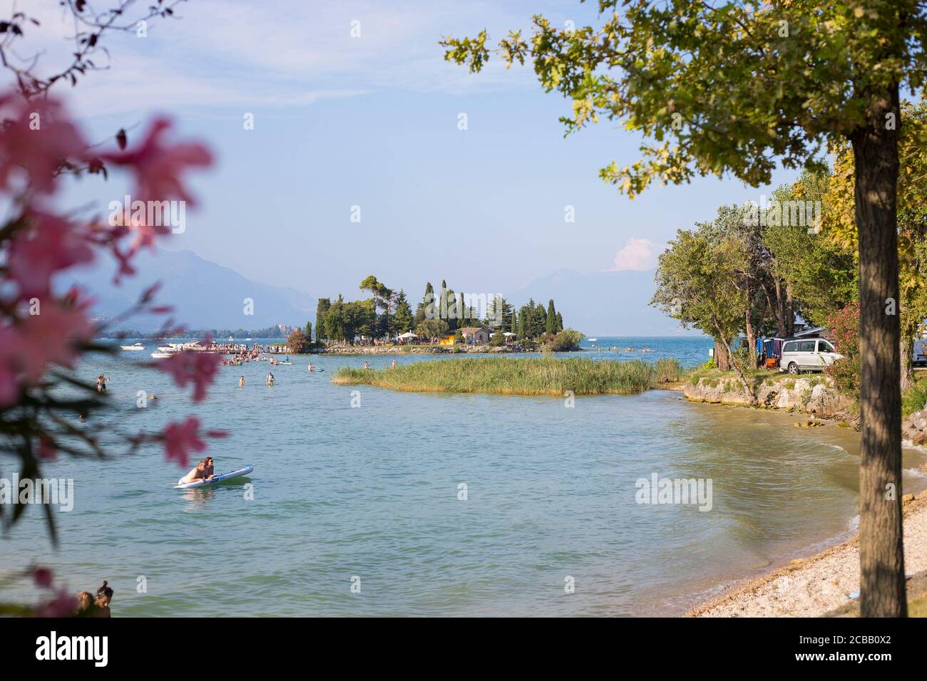 San Biagio Insel Fernsicht vom San Biagio Campingplatz, mit Bäumen und Blumen umrahmt. manerba del Garda, Lombardei, Italien. Stockfoto