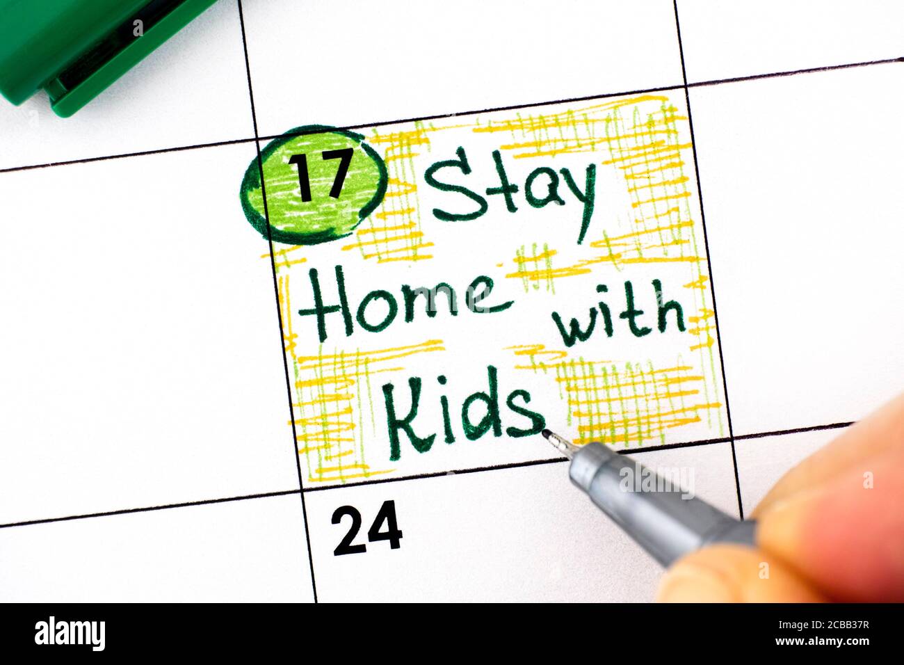 Frau Finger mit Stift Schreiben Erinnerung Aufenthalt zu Hause mit Kindern im Kalender. August 17. Stockfoto