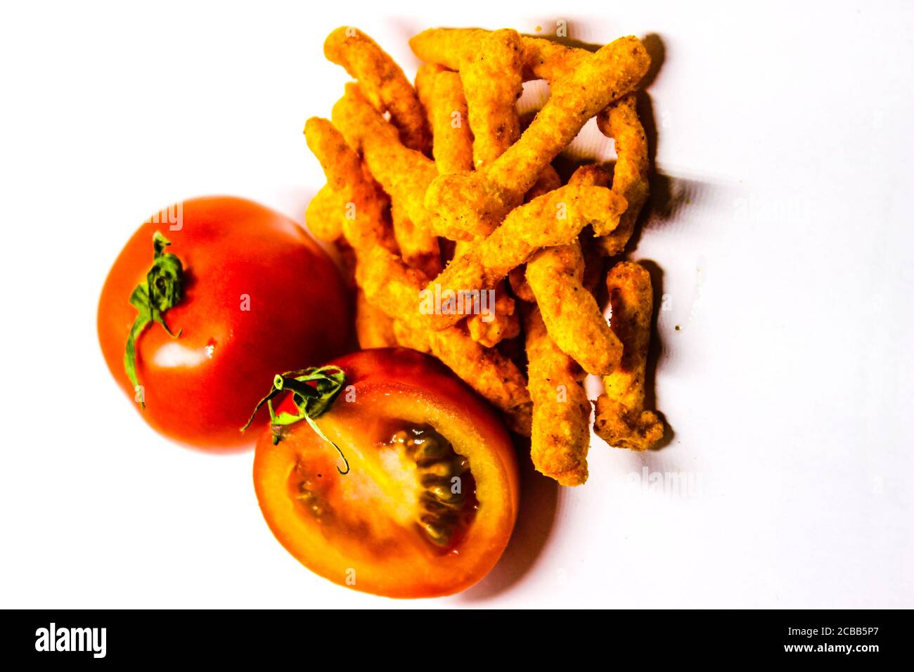 Ein Bild von frischen Tomaten und Kurkure mit weißem Hintergrund Stockfoto