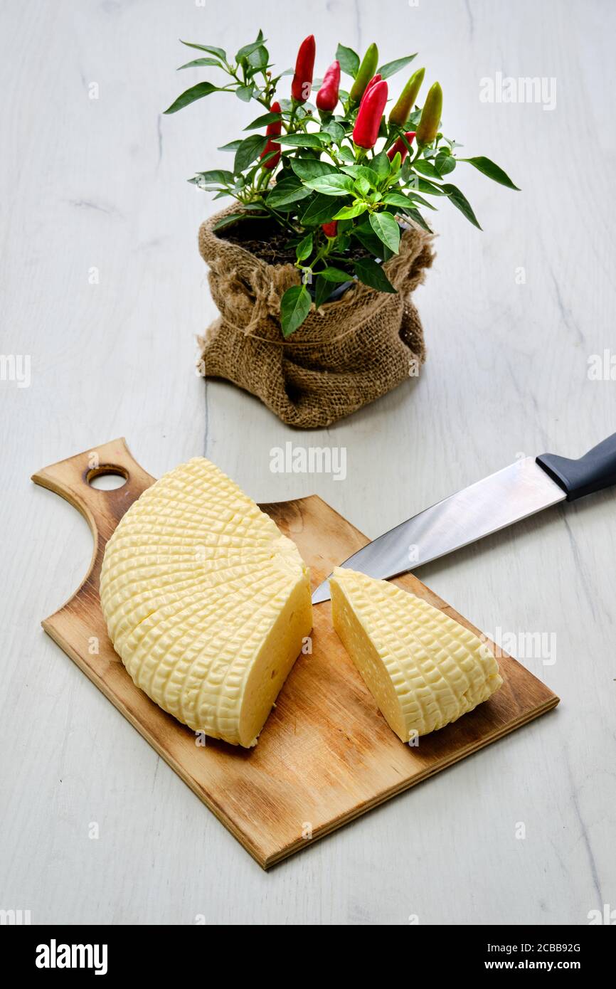 Frischer Adyghe-Käse auf Scheiben auf Holzschneidebrett geschnitten Stockfoto