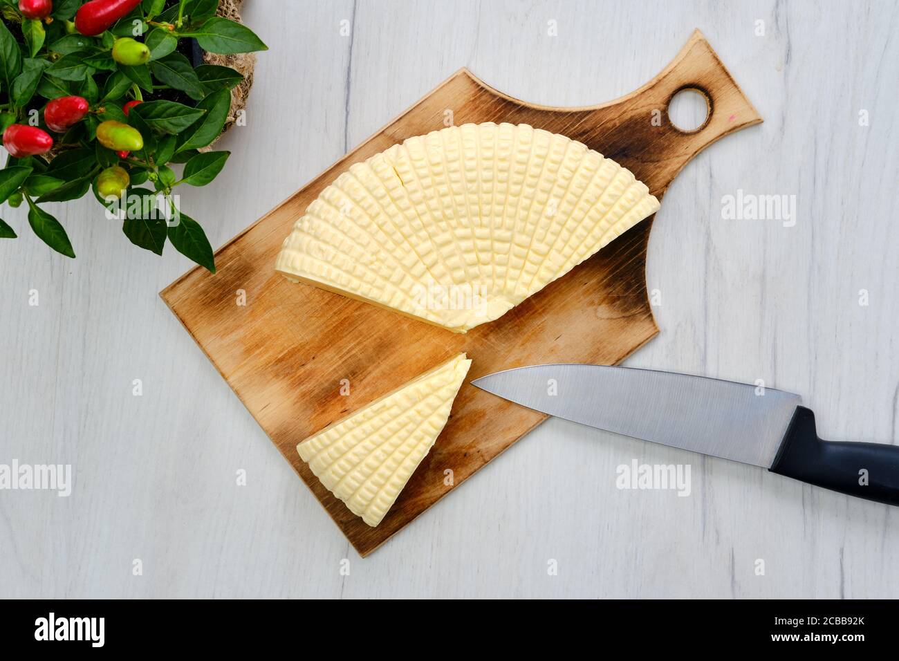 Frischer Adyghe-Käse auf Scheiben auf Holzschneidebrett geschnitten Stockfoto