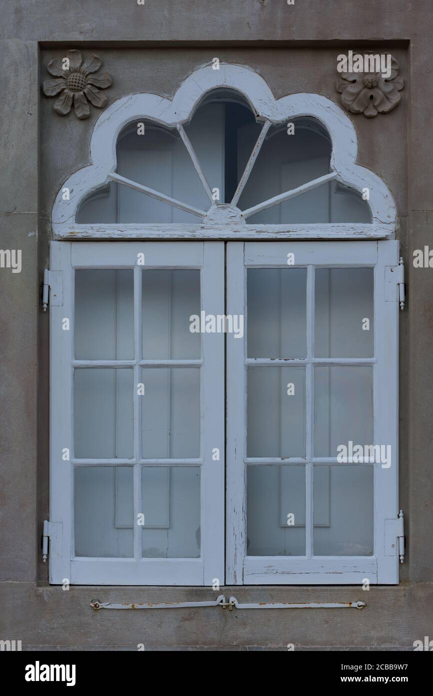 Ein schönes altes Fenster mit einem weißen Holzrahmen und schmückt die Wände des Pena Palastes in Sintra, Portugal. Stockfoto
