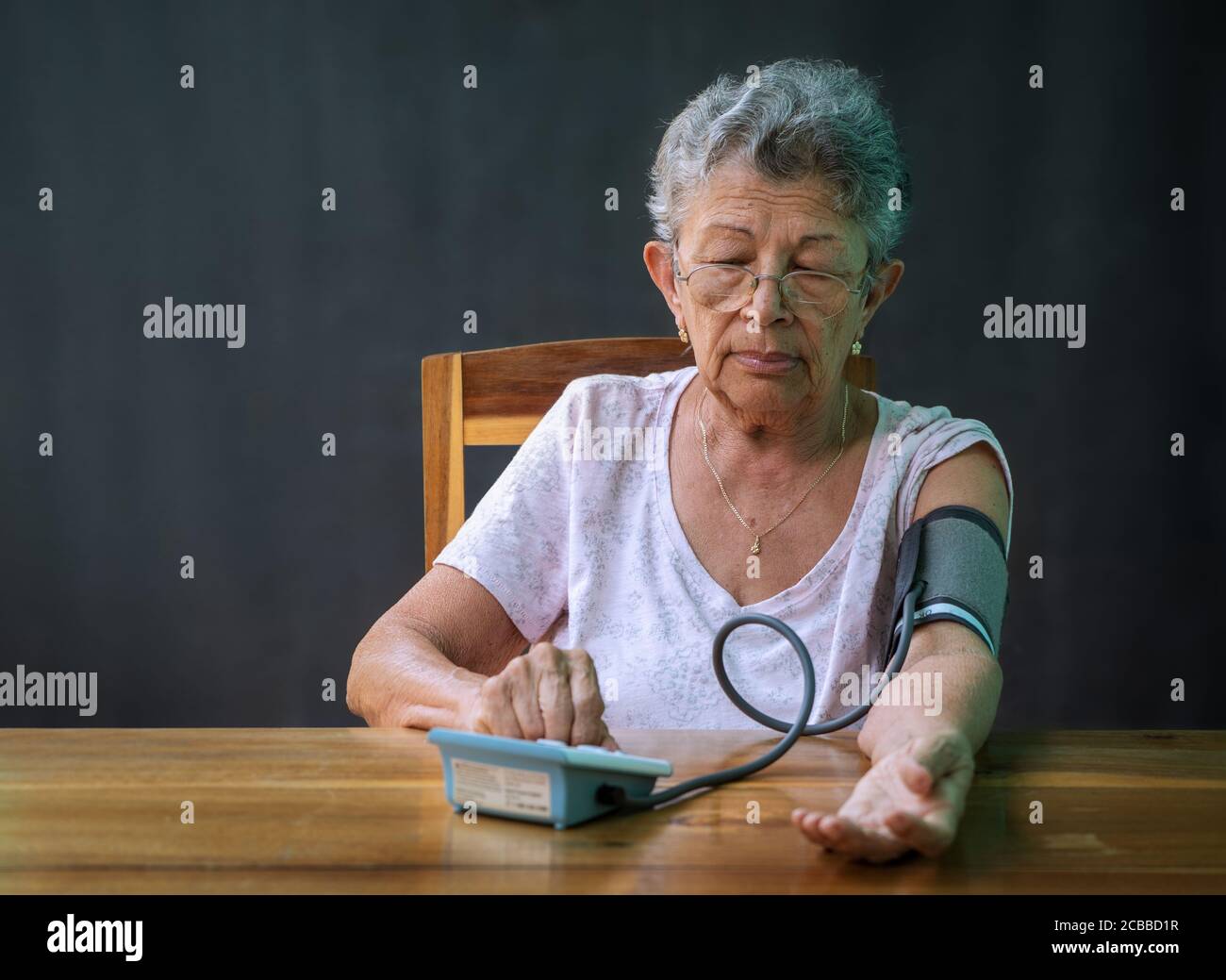 Ältere Frau, die ihren Blutdruck misst. Stockfoto