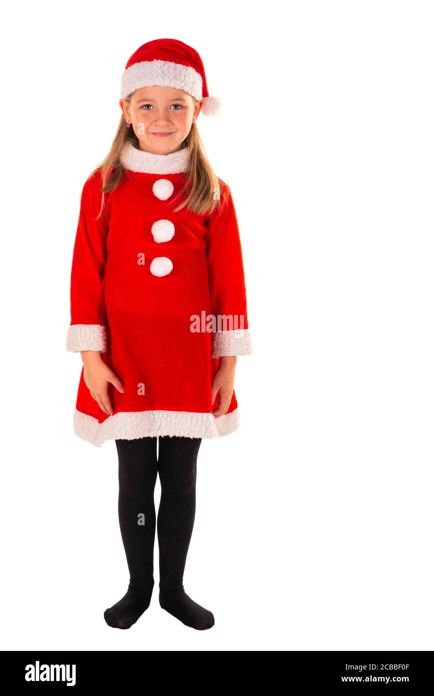 In voller Länge Porträt von schönen 8 Jahre altes Mädchen mit Armen neben Körper stehend tragen rote weihnachtskostüm mit einem roten Kleid, Weihnachtsmann Hut und Stockfoto