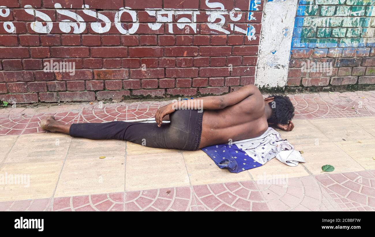 Obdachloser Mann, der am Straßenrand schläft Stockfoto