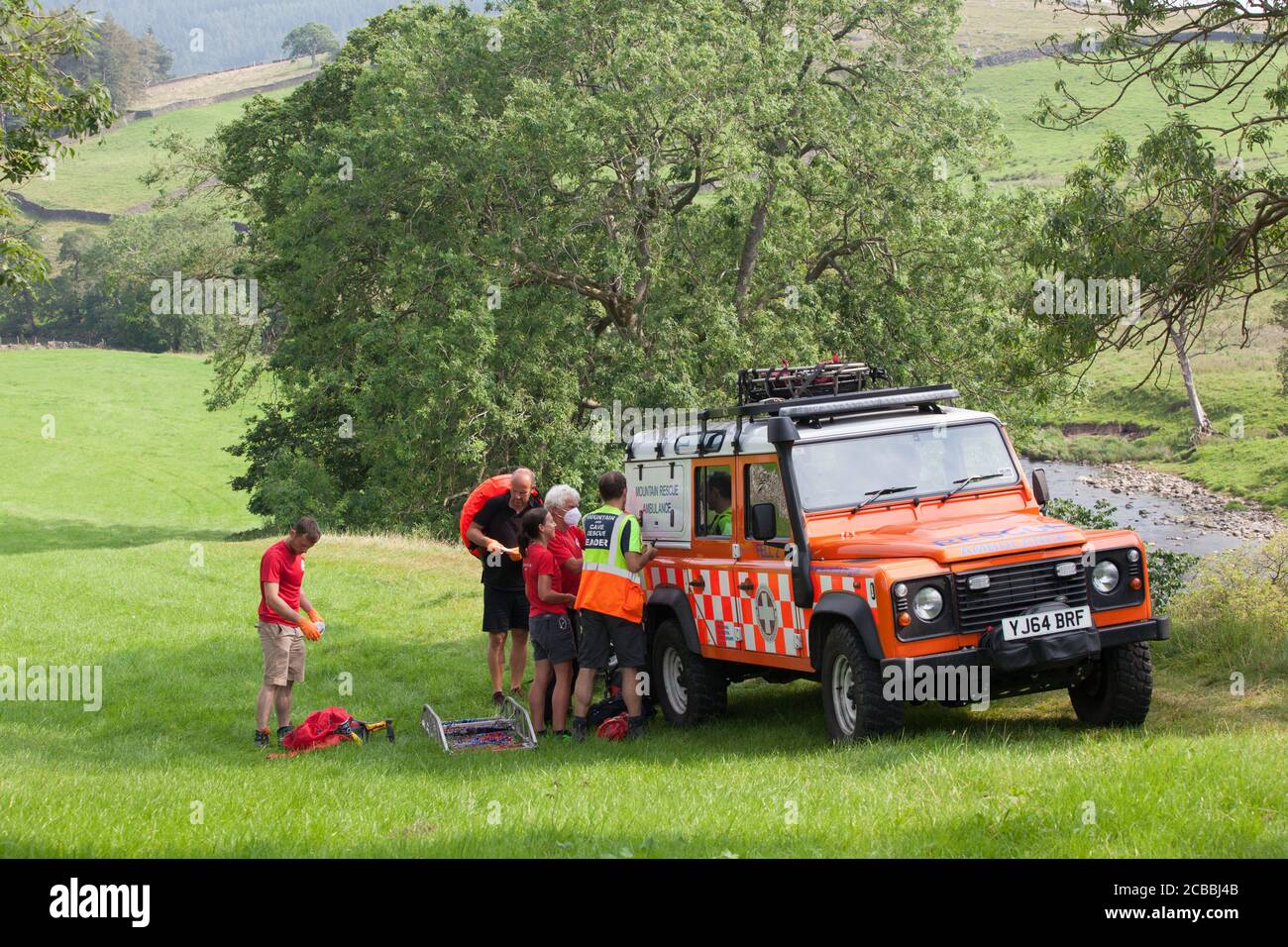 Yorkshire, Großbritannien, 12. August 2020: Eine Rettungsmannschaft und ein Bergrettung-Team wurden in die Nähe von Appletreewick gerufen, wo eine Frau einen vermuteten gebrochenen Knöchel hatte und aus dem Krankenhaus ausgestreckt werden musste. Dutzende Urlauber und Einheimische nutzten die 28 Grad Hitze, um im Fluss Wharfe im Yorkshire Dales National Park zu schwimmen. Anna Watson/Alamy Live News Stockfoto