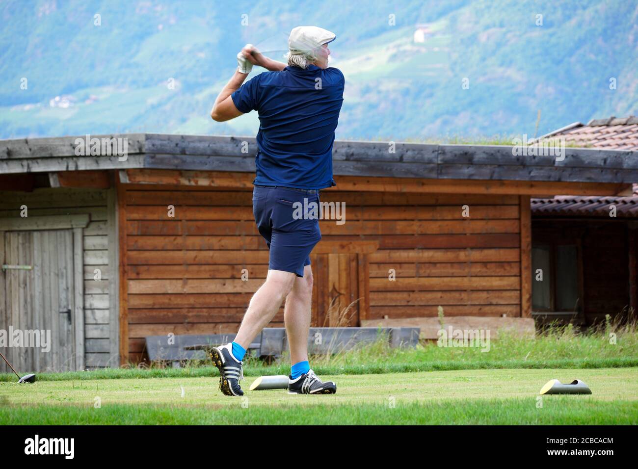 Verschwommene Bewegung eines männlichen Golfers beim Abschlag im Blue Monster Golfclub in Südtirol, Italien im Sommer 2020. Stockfoto