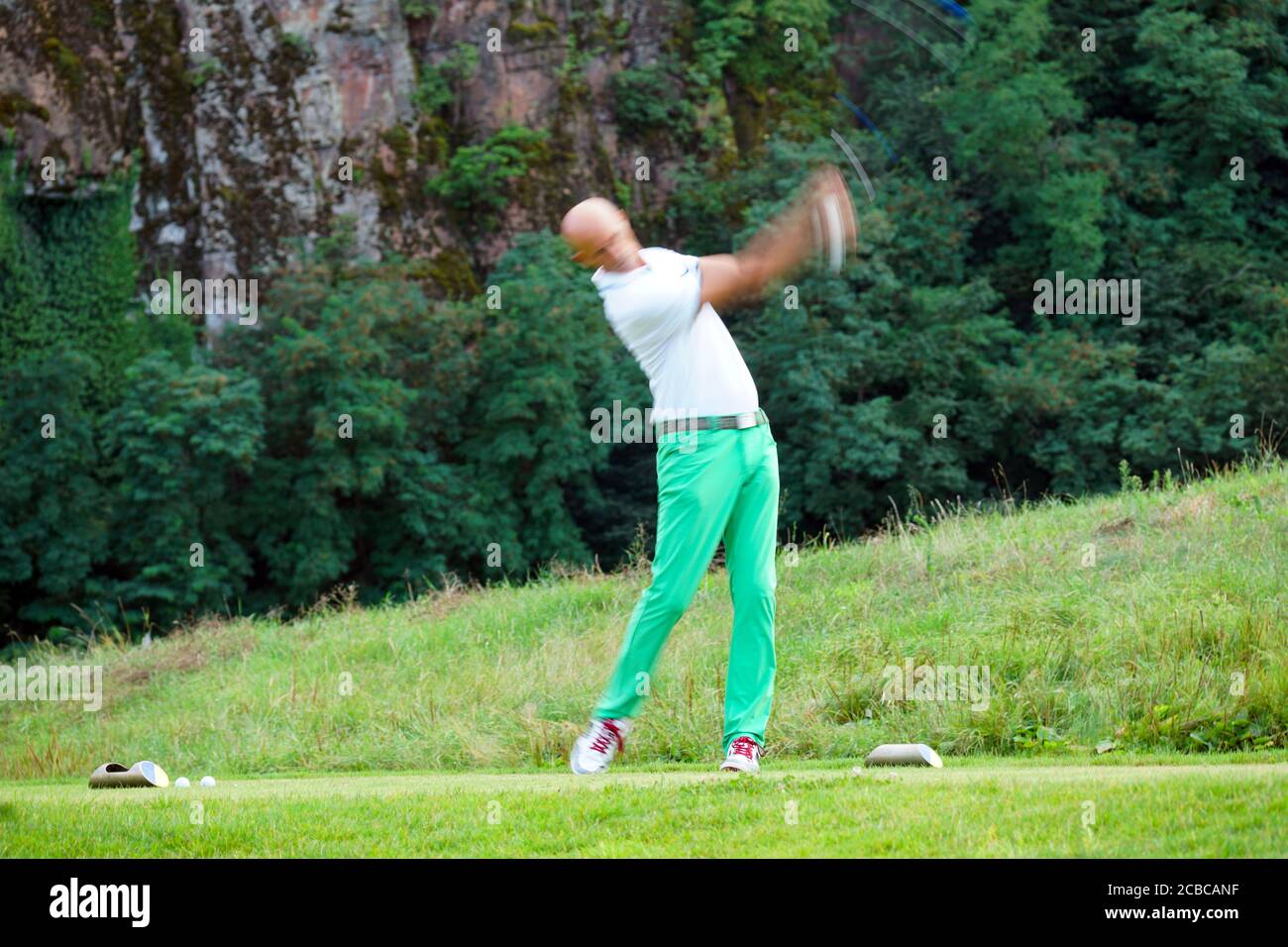 Verschwommene Bewegung eines männlichen Golfers beim Abschlag im Blue Monster Golfclub in Südtirol, Italien im Sommer 2020. Stockfoto
