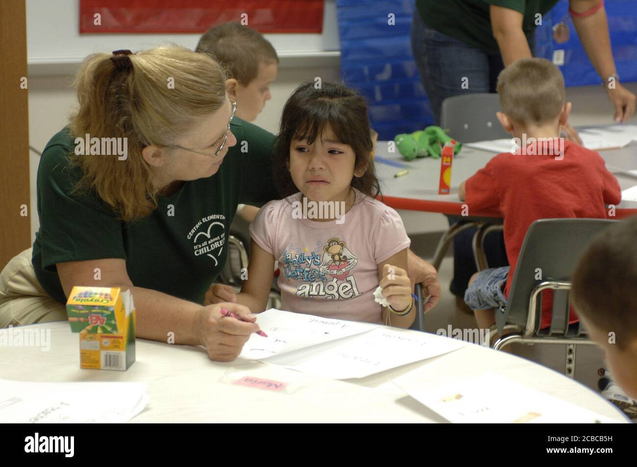 Mabank, Texas, USA, 17. August 2006: Während der ersten Unterrichtswoche an der Mabank Central Elementary School tröstet ein Kindergartenlehrer einen weinenden Schüler während der Kunstzeit. ©Bob Daemmrich Stockfoto