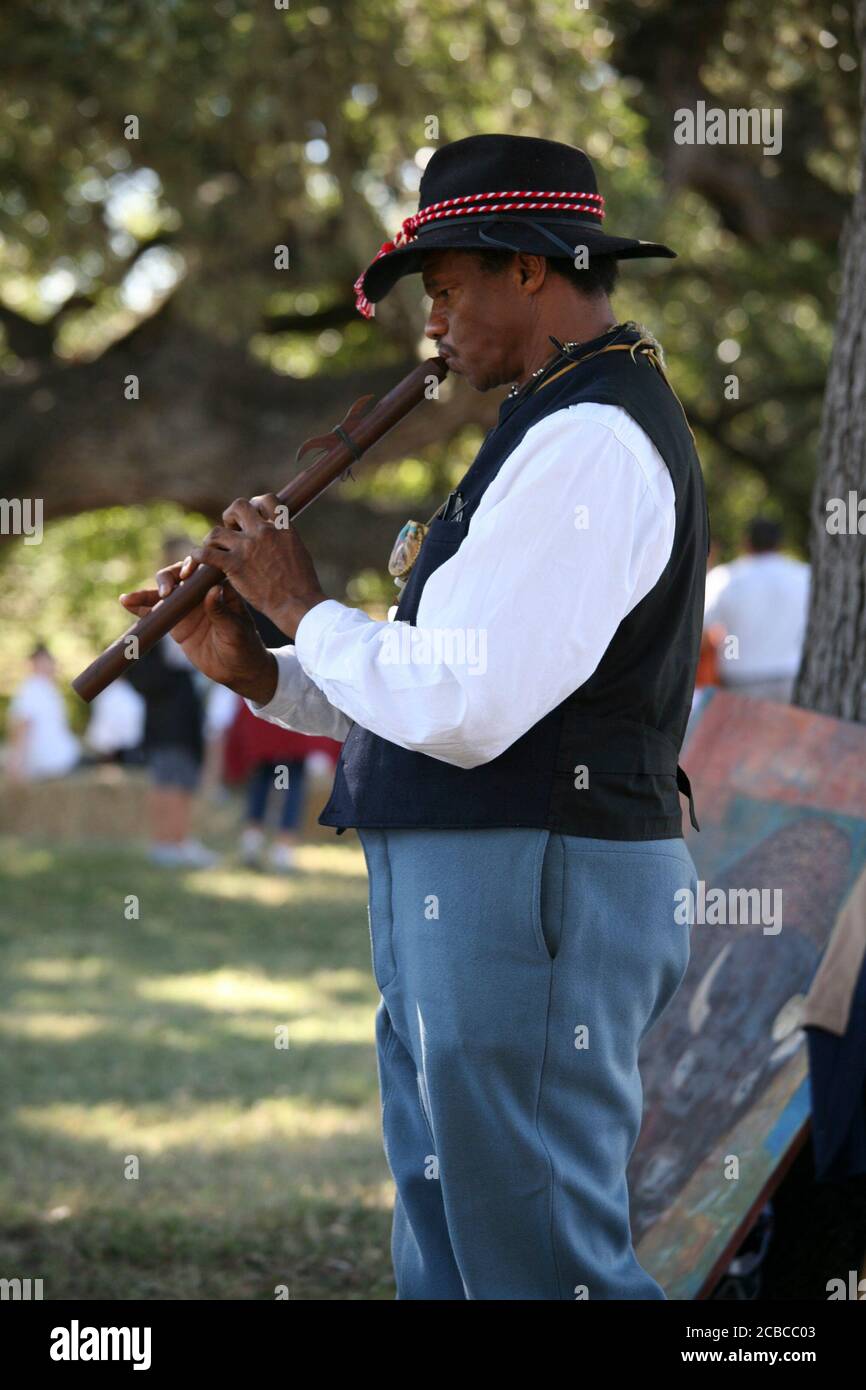 Stonewall, Texas, USA, Oktober 2007: Afroamerikanischer Mann, der als Buffalo Soldier gekleidet ist, beschreibt das tägliche Leben schwarzer Soldaten an der texanischen Grenze in den 1860er Jahren an Jungen und Mädchen der fünften Klasse, die auf einem Feldausflug in die Johnson Settlement Section des Lyndon B. Johnson National Historical Park in Johnson City, Texas, unterwegs sind. Die Schüler erfahren, wie die frühen Anglo-Siedler, einschließlich des Urgroßvaters von LBJ, in den 1860er Jahren an der texanischen Grenze lebten ©Bob Daemmrich Stockfoto