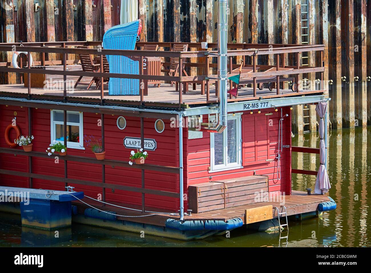 Ein Hausboot mit Liegestuhl auf dem Oberdeck im Binnenhafen von Boizenburg / Elbe, Norddeutschland Stockfoto