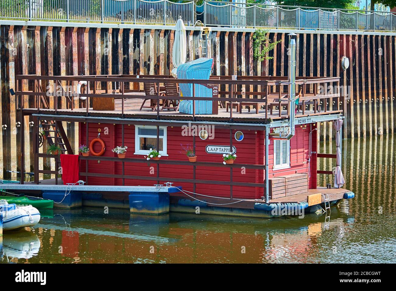 Ein Hausboot mit Liegestuhl auf dem Oberdeck im Binnenhafen von Boizenburg / Elbe, Norddeutschland Stockfoto